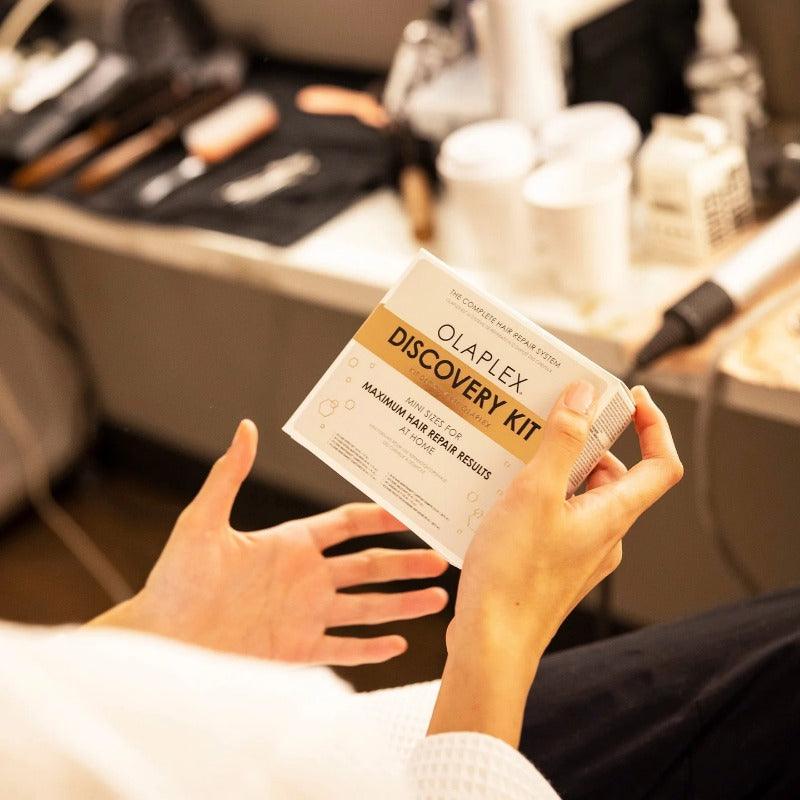 Women holding a olaplex discovery kit in a hair salon