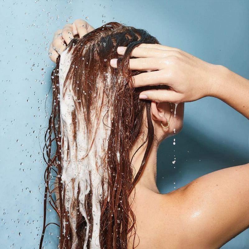 Olaplex Shampoo being used in shower on hair